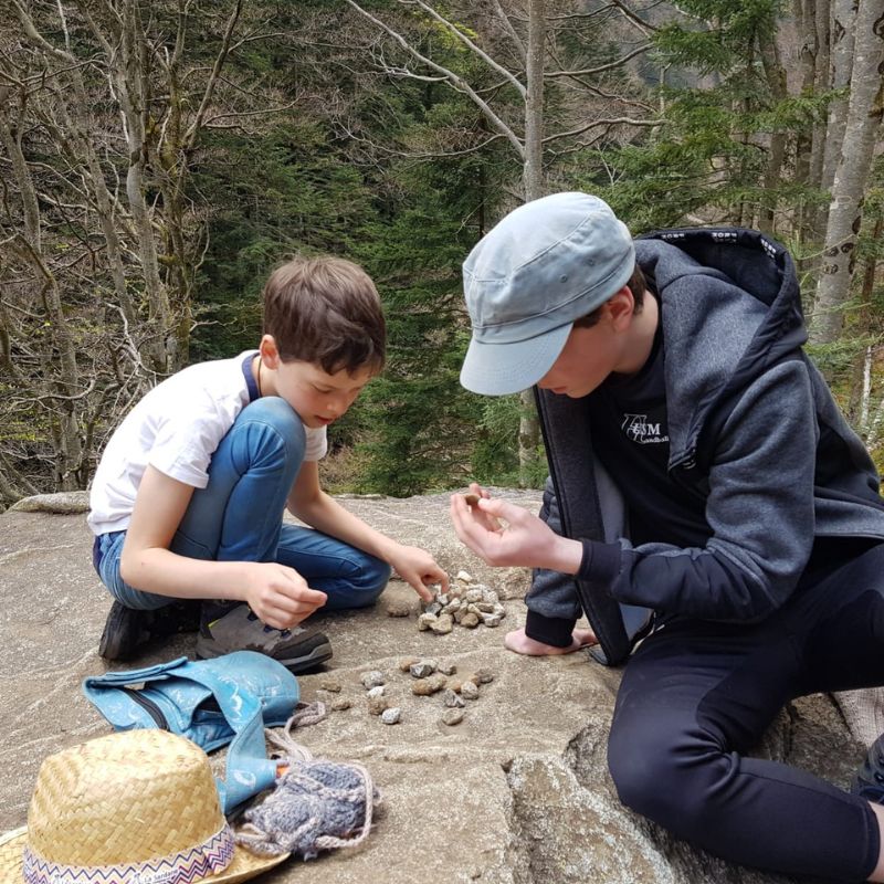 jeux enfant et adolescent avec des cailloux en pleine nature